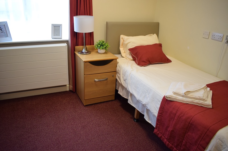 Bedroom with red sheets and carpet